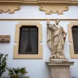 Il piano terra, sul quale si aprono i due ingressi al Palazzo, � abbellito dalle seicentesche statue in pietra dei santi Pietro...